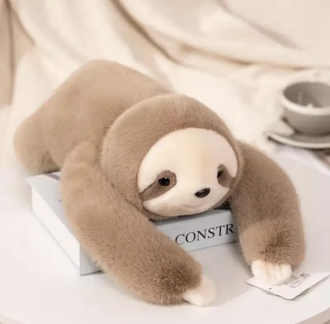 A happy customer hugging Sally the weighted sloth on a couch